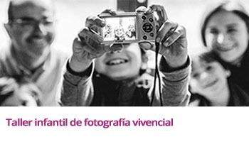 Niño con una cámara digital preparada (objetivo apuntando hacia él) y a punto de hacer una fotografía (estilo 'selfie') junto al resto de la familia que le rodea (padre, madre y dos hermanos)